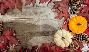 festliche herbstdekoration aus kürbissen, kiefern und blättern auf einem hölzernen hintergrund. konzept des erntedankfestes oder halloweens. flach gelegte herbstkomposition mit kopierraum. foto