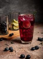 Blaubeer-Mojito eine sommerliche Erfrischung aus Blaubeere, kühl serviert mit einem Schuss Limette und Soda foto