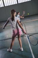 junge Mädchen, die Indoor-Tennisspiel spielen foto