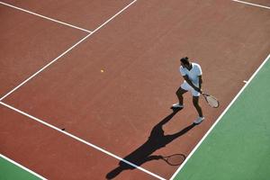 junger mann spielt tennis foto