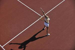 junge Frau spielt Tennis im Freien foto