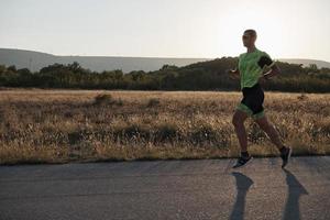 triathlonsportler, der beim morgendlichen training läuft foto