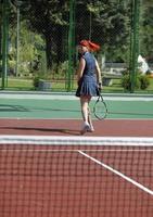 junge frau spielt tennisspiel im freien foto