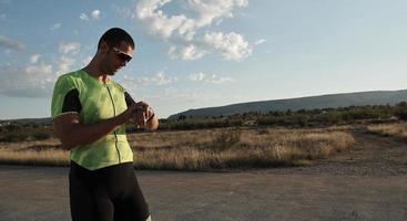 triathlon athlet ruht und setzt smartwatch foto