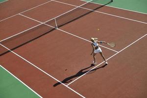 junge Frau spielt Tennis im Freien foto