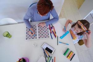 mutter und kleine tochter spielen zusammen und zeichnen kreative kunstwerke foto