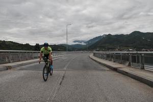 triathlonsportler, der beim morgendlichen training fahrrad fährt foto