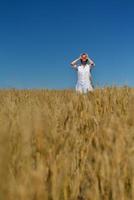 junge Frau im Weizenfeld im Sommer foto