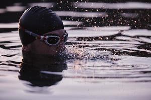 triathlet-schwimmer, der während des harten trainings eine pause macht foto