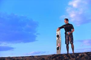 Porträt eines jungen Kitsurf-Mannes am Strand bei Sonnenuntergang foto