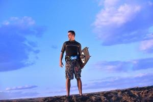 Porträt eines jungen Kitsurf-Mannes am Strand bei Sonnenuntergang foto