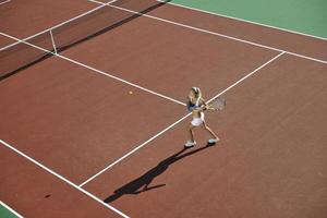 junge Frau spielt Tennis im Freien foto