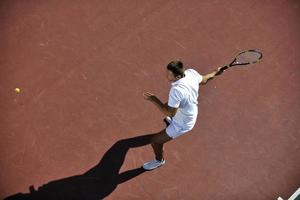 junger mann spielt tennis foto