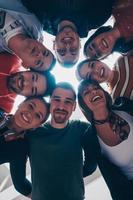 Gruppe glücklicher junger Menschen, die ihre Einheit zeigen foto