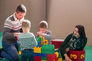 junge eltern und kinder haben spaß im kinderspielzimmer foto