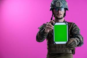 Soldat, der ein Tablet mit einem leeren grünen Bildschirm zeigt foto