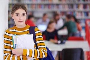 der Schüler benutzt ein Notizbuch und eine Schulbibliothek foto