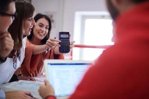 studentengruppe, die gemeinsam an einem schulprojekt auf einem tablet-computer an einer modernen universität arbeitet foto