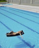 Schöne Frau am Pool entspannen foto