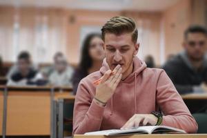 Student, der sich während des Studiums in der High School Notizen macht foto