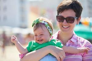 Mama und Baby am Strand haben Spaß foto