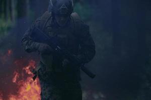 Soldat in Aktion bei Nacht beim Springen über Feuer foto