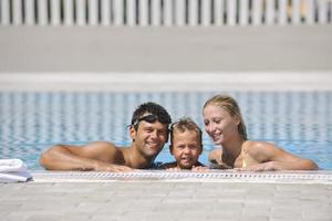 glückliche junge familie hat spaß am schwimmbad foto