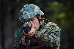 soldat in aktion, der auf waffenlaservisieroptik abzielt foto