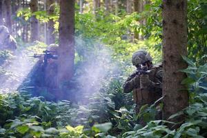 soldat in aktion, der auf waffenlaservisieroptik abzielt foto