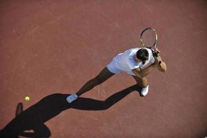 junger Mann spielt Tennis im Freien foto