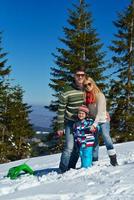 familie, die spaß auf frischem schnee im winterurlaub hat foto