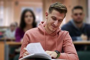 Student, der sich während des Studiums in der High School Notizen macht foto