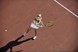 junge Frau spielt Tennis im Freien foto