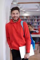 der Schüler benutzt einen Laptop und eine Schulbibliothek foto