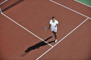 junge Frau spielt Tennis im Freien foto