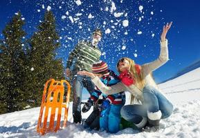 familie, die spaß auf frischem schnee im winter hat foto