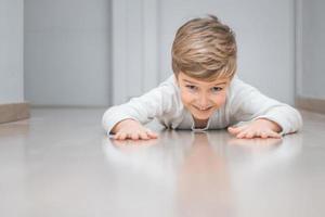 Verspielter Junge, der auf dem Boden krabbelt. foto