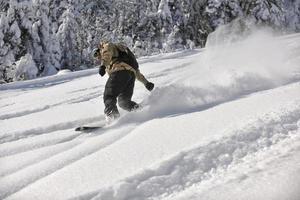 Freestyle-Snowboarder springen und fahren foto