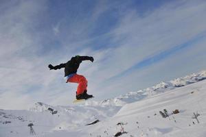 glücklicher junger mann hat spaß im winter auf dem berggipfel foto