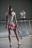 junge Mädchen, die Indoor-Tennisspiel spielen foto