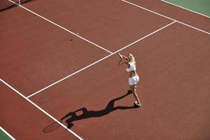 junge Frau spielt Tennis im Freien foto