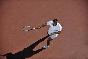 junger mann spielt tennis foto