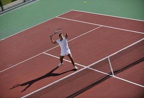 junger mann spielt tennis foto