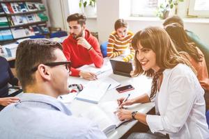 studentengruppe, die gemeinsam an einem schulprojekt auf einem tablet-computer an einer modernen universität arbeitet foto