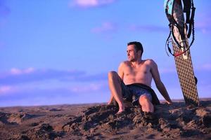 Porträt eines jungen Kitsurf-Mannes am Strand bei Sonnenuntergang foto