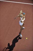 junge Frau spielt Tennis im Freien