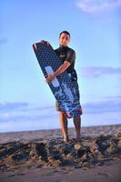 Porträt eines jungen Kitsurf-Mannes am Strand bei Sonnenuntergang foto