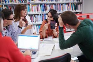 studentengruppe, die gemeinsam an einem schulprojekt auf einem tablet-computer an einer modernen universität arbeitet foto