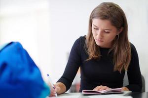 schüler, der notizen für die schulklasse macht foto