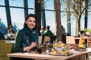 junge Frau, die im Restaurant zu Mittag isst foto